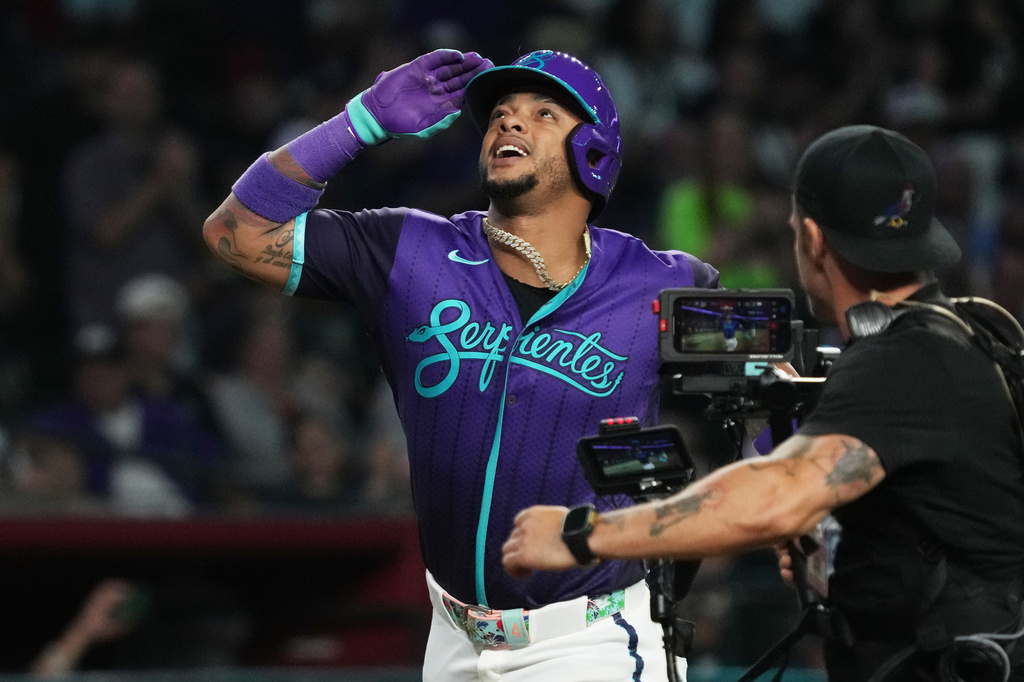 Arizona Diamondbacks' Ketel Marte, left, reacts after hitting a solo home run against the Minnesota Twins in the sixth inning of a baseball game, Friday, June 19, 2026, in Phoenix. (AP Photo/Rick Scuteri)