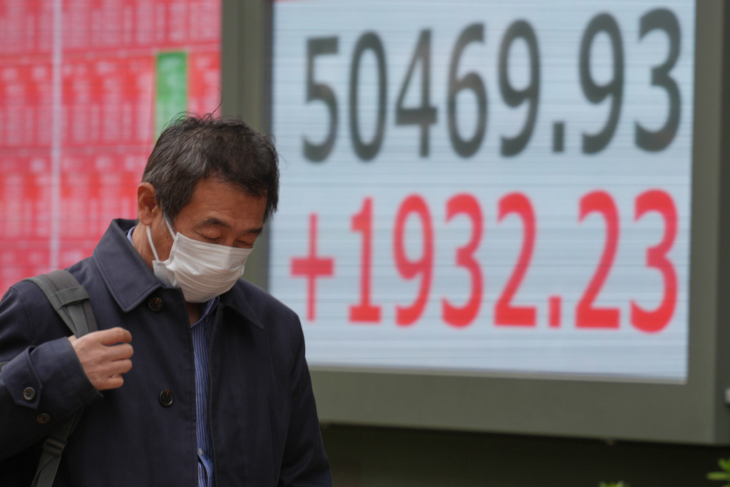 A person walks in front of an electronic stock board showing Japan's Nikkei index at a securities firm Thursday, Nov. 20, 2025, in Tokyo. (AP Photo/Eugene Hoshiko)