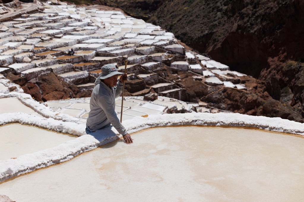 Uriel inspects one of his family's salt ponds at Salineras de Maras, Maras salt mines, in the Sacred Valley near Cusco, Peru on Sunday, Aug. 31, 2025. (AP Photo/Alie Skowronski)
