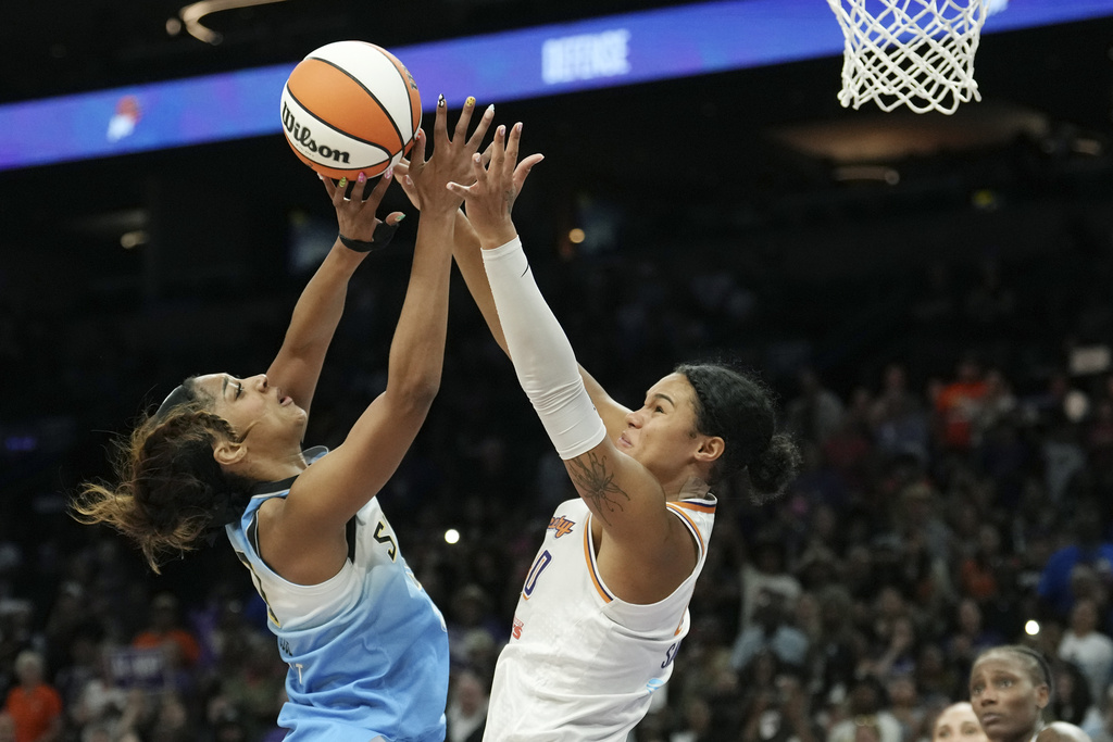 Chicago Sky forward Angel Reese, left, gets off a shot against Phoenix Mercury forward Satou Sabally (0) during the second half of a WNBA basketball game Thursday, Aug. 28, 2025, in Phoenix. (AP Photo/Ross D. Franklin)