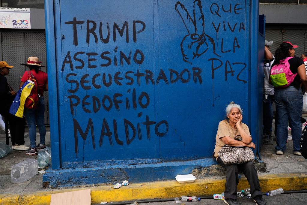 Graffiti that reads in Spanish, "Trump: murderer, kidnapper, pedophile, damned," left, and "Long live peace," covers a kiosk during a march to demand President Nicolas Maduro's return, in Caracas, Venezuela, Tuesday, Jan. 6, 2026, three days after U.S. forces captured him and his wife. (AP Photo/Matias Delacroix)