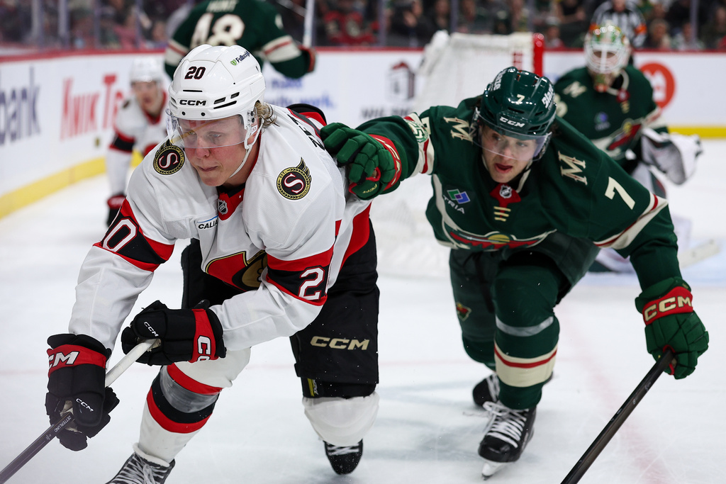 Ottawa Senators left wing Fabian Zetterlund, left, and Minnesota Wild defenseman Brock Faber (7) compete for the puck during the third period of an NHL hockey game Saturday, Dec. 13, 2025, in St. Paul, Minn. (AP Photo/Matt Krohn)