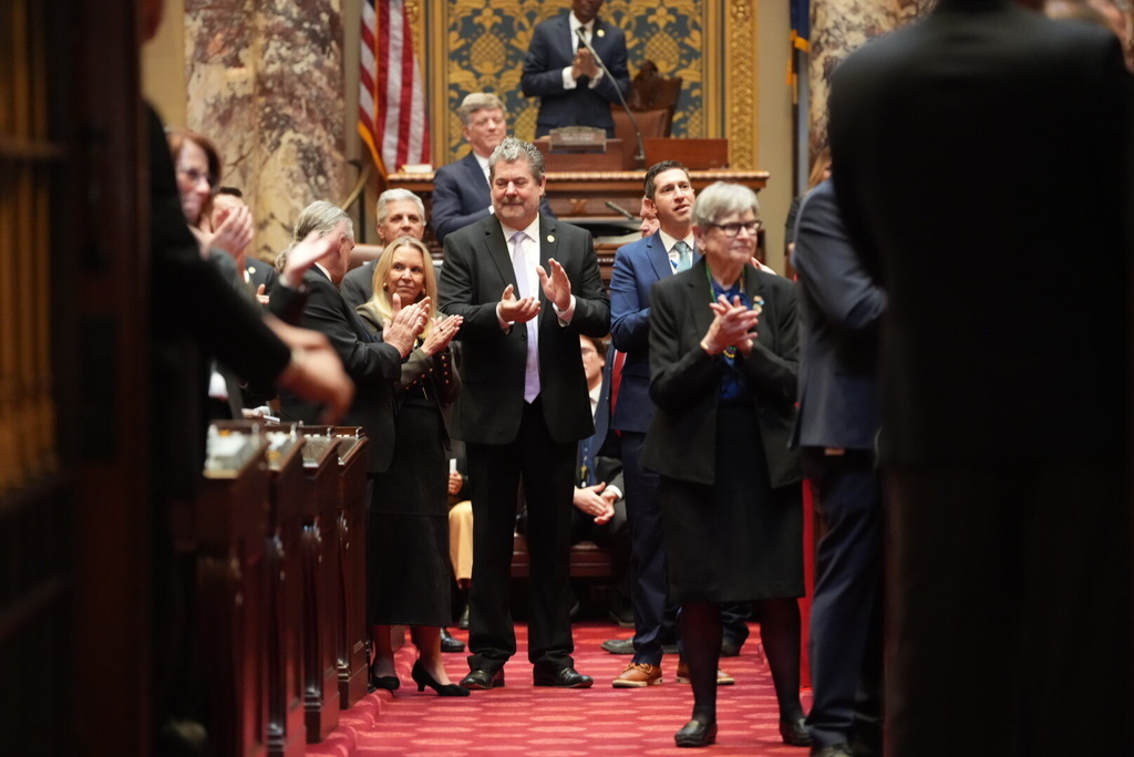 Legislators greet Sen. John Hoffman, not pictured, with applause as he enters the Senate chambers on the first day of the 2026 legislative session at the Minnesota State Capitol on Tuesday, Feb. 17, 2026 in St. Paul, Minn. Tuesday was Hoffman's first day back to the legislature since being shot in his home in June 2025. (Alex Kormann/Star Tribune via AP)