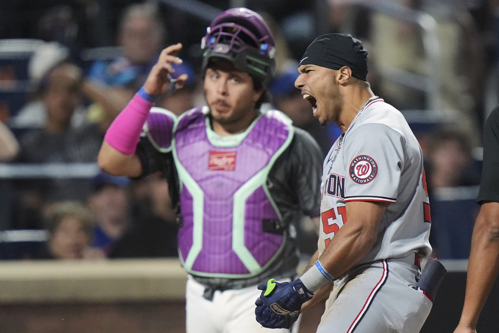 New York Mets catcher Francisco Alvarez, left, watches as Washington Nationals' Daylen Lile (51) celebrates after hitting a two-run inside-the-park home run during the 11th inning of a baseball game Saturday, Sept. 20, 2025, in New York. (AP Photo/Frank Franklin II)