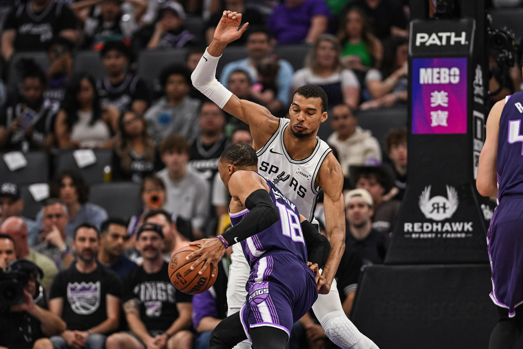 San Antonio Spurs forward Victor Wembanyama (1) defends Sacramento Kings guard Russell Westbrook (18) during the first half of an NBA basketball game, Tuesday, March 17, 2026, in Sacramento, Calif. (AP Photo/Justine Willard)