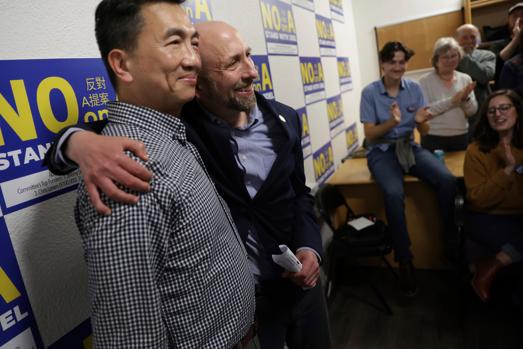 Supervisor Joel Engardio, second left, hugs his husband, Lionel Hsu, as supporters applaud after Engardio lost recall election in San Francisco on Tuesday, Sept. 16, 2025. (Scott Strazzante/San Francisco Chronicle via AP)