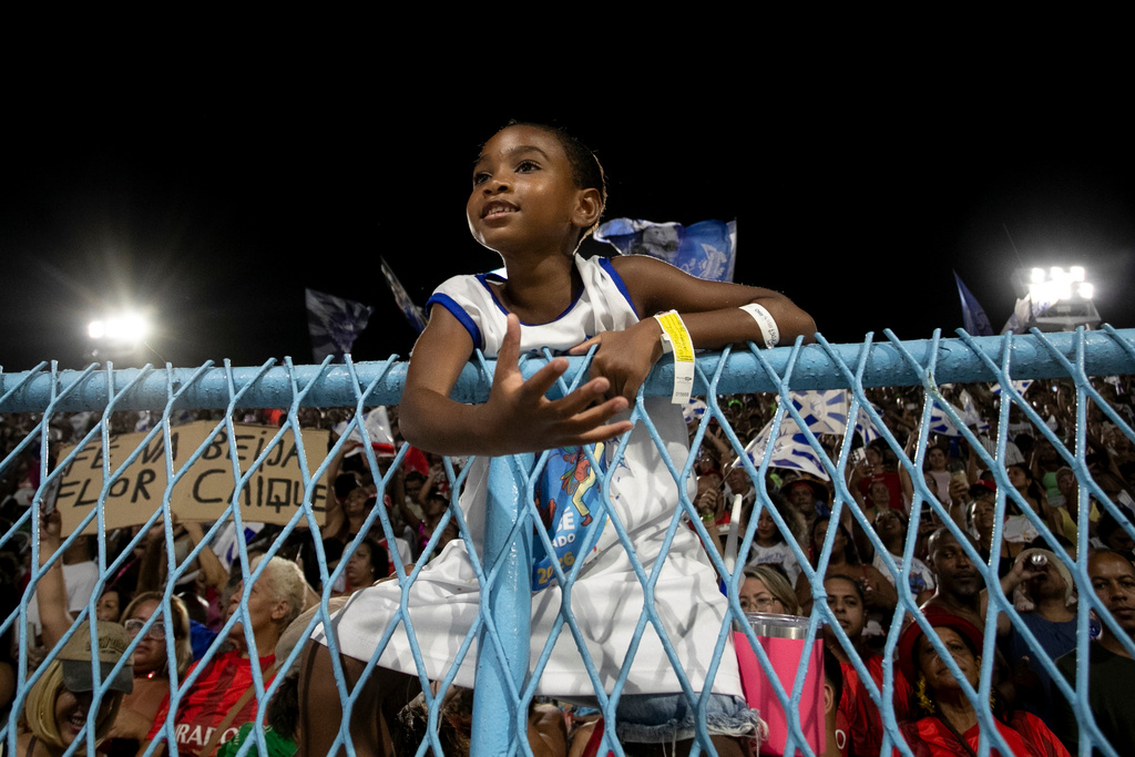 A child watches a parade of the Beija-Flor samba school during Carnival celebrations at the Sambadrome in Rio de Janeiro, Monday, Feb. 16, 2026. (AP Photo/Bruna Prado)