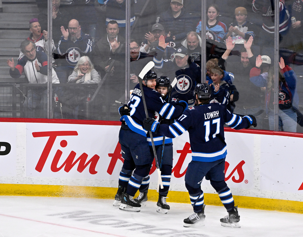 Winnipeg Jets' Cole Perfetti celebrates his goal on the Vegas Golden Knights with Gabriel Vilardi (13) and Adam Lowry (17) during the second period of their NHL hockey game in Winnipeg, Tuesday, March 24, 2026. (Fred Greenslade/The Canadian Press via AP)