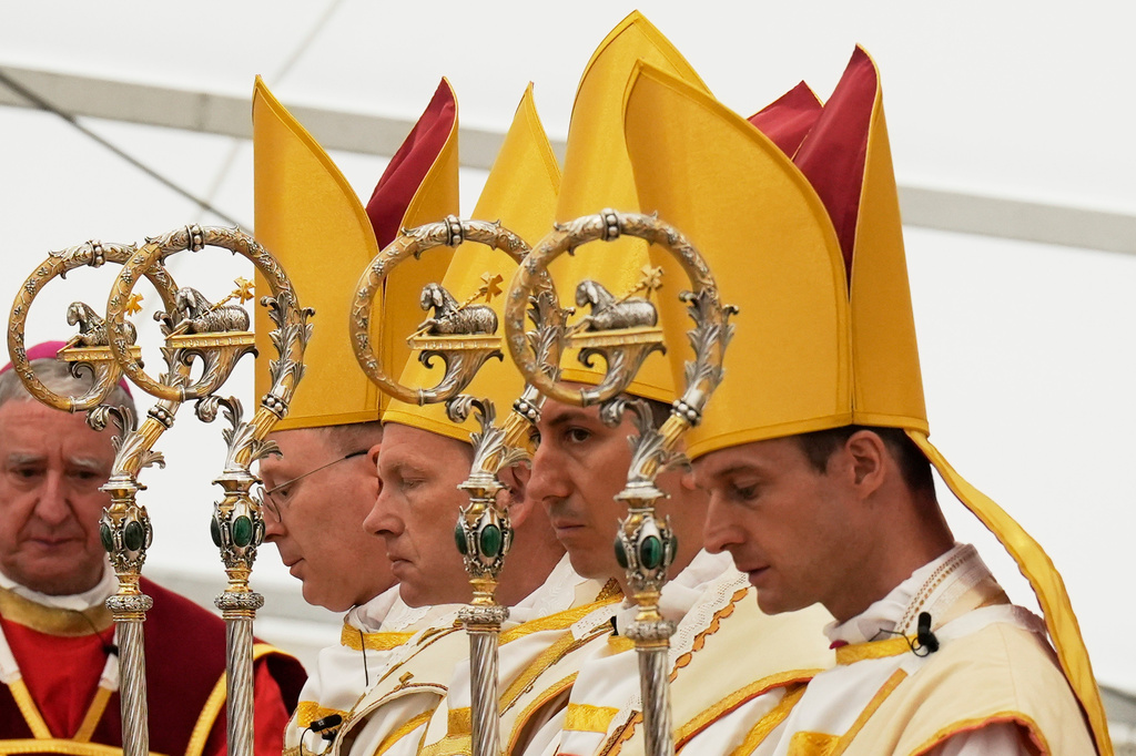 Newly consecrated Bishops, from left, Pascal Schreiber, Michael Goldade, Michel Poinsinet de Sivry and Marc Hanappier, wearing their miters and holding their pastoral staffs, pray at the end of their consecration ceremony in a tent set up outside the Society of St. Pius X seminary in Econe, Switzerland, Wednesday, July 1, 2026. (AP Photo/Baz Ratner)