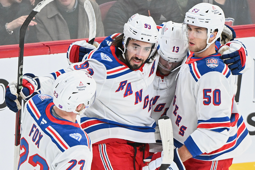 New York Rangers' Mika Zibanejad (93) celebrates with teammates Adam Fox (23), Alexis Lafreniere (13) and Will Cuylle (50) after scoring against the Montreal Canadiens during the first period of an NHL hockey game in Montreal, Saturday, Oct. 18, 2025. (Graham Hughes/The Canadian Press via AP)