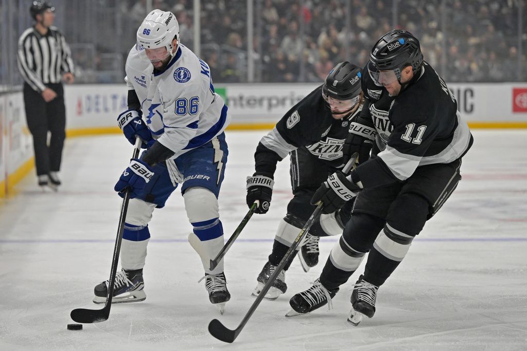 Tampa Bay Lightning right wing Nikita Kucherov (86) is defended by Los Angeles Kings right wing Adrian Kempe and Kings' center Anze Kopitar (11) during the first period of an NHL hockey game, Thursday, Jan. 1, 2026, in Los Angeles. (AP Photo/Jayne Kamin-Oncea)