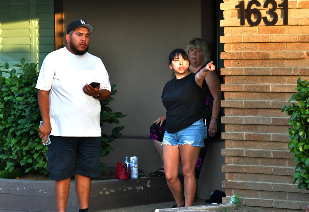Family members of hostages wait a block away from a bank building where a man barricaded himself inside with hostages Tuesday, June 2, 2026, in Bakersfield, Calif. (AP Photo/Erick Madrid)