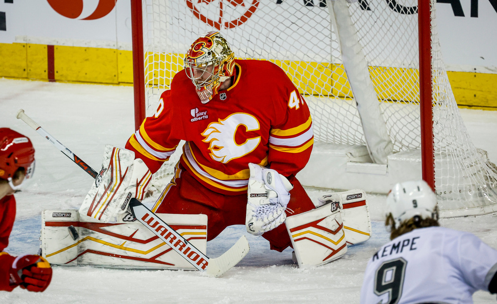 Los Angeles Kings' Adrian Kempe, right, looks on as Calgary Flames goalie Arsenii Sergeev kicks away his shot during the first period of an NHL hockey game in Calgary, Thursday, April 16, 2026. (Jeff McIntosh/The Canadian Press via AP)