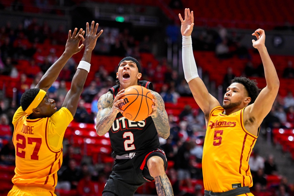 Utah guard Terrence Brown (2) shoots between Iowa State guard Killyan Toure (27) and Iowa State forward Joshua Jefferson (5) during the first half of an NCAA college basketball game, Tuesday, Feb. 24, 2026, in Salt Lake City. (AP Photo/Alex Goodlett)