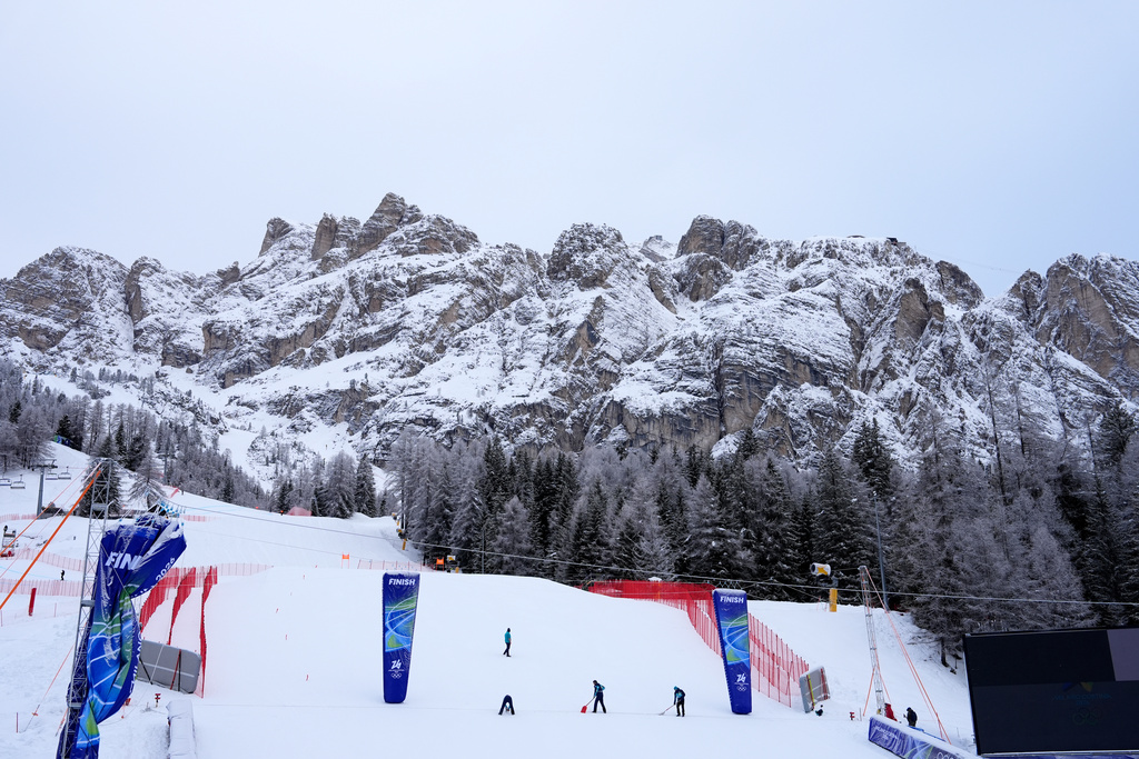 Race officials prepare the course ahead of an alpine ski, women's downhill official training, at the 2026 Winter Olympics, in Cortina d'Ampezzo, Italy, Friday, Feb. 6, 2026. (AP Photo/Giovanni Auletta)