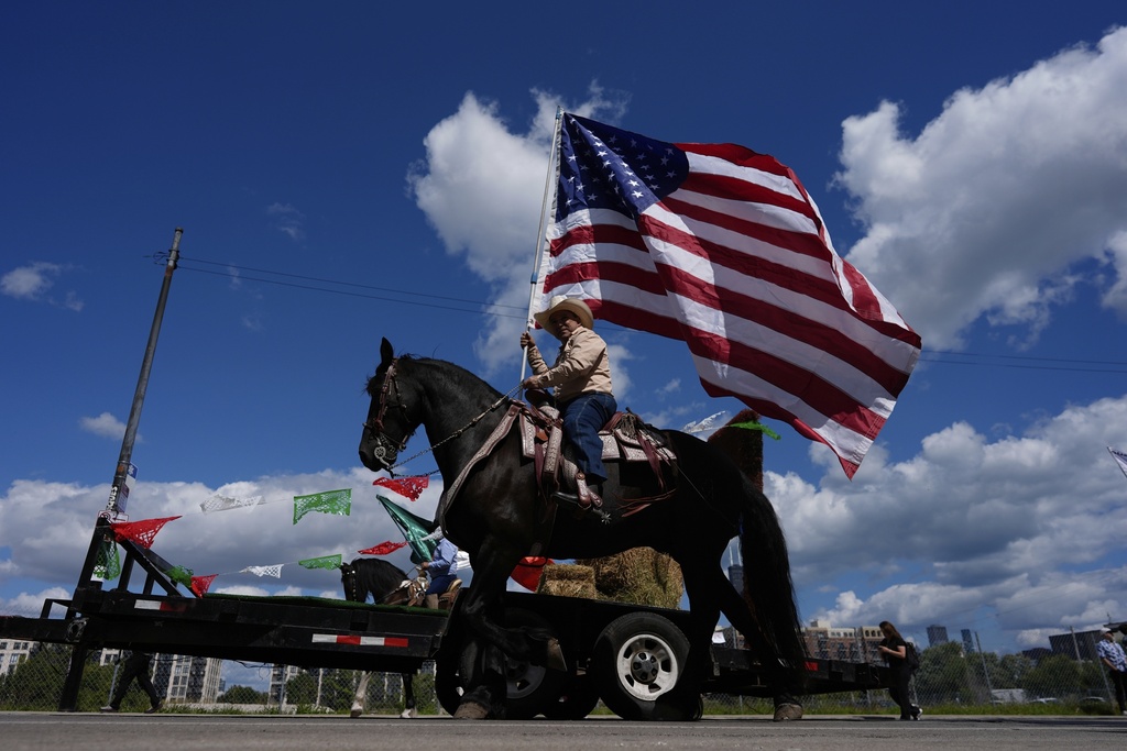 Participants wave flags during the 2025 Pilsen Mexican Independence Day parade Saturday, Sept. 6, 2025, in Chicago. (AP Photo/Carolyn Kaster)