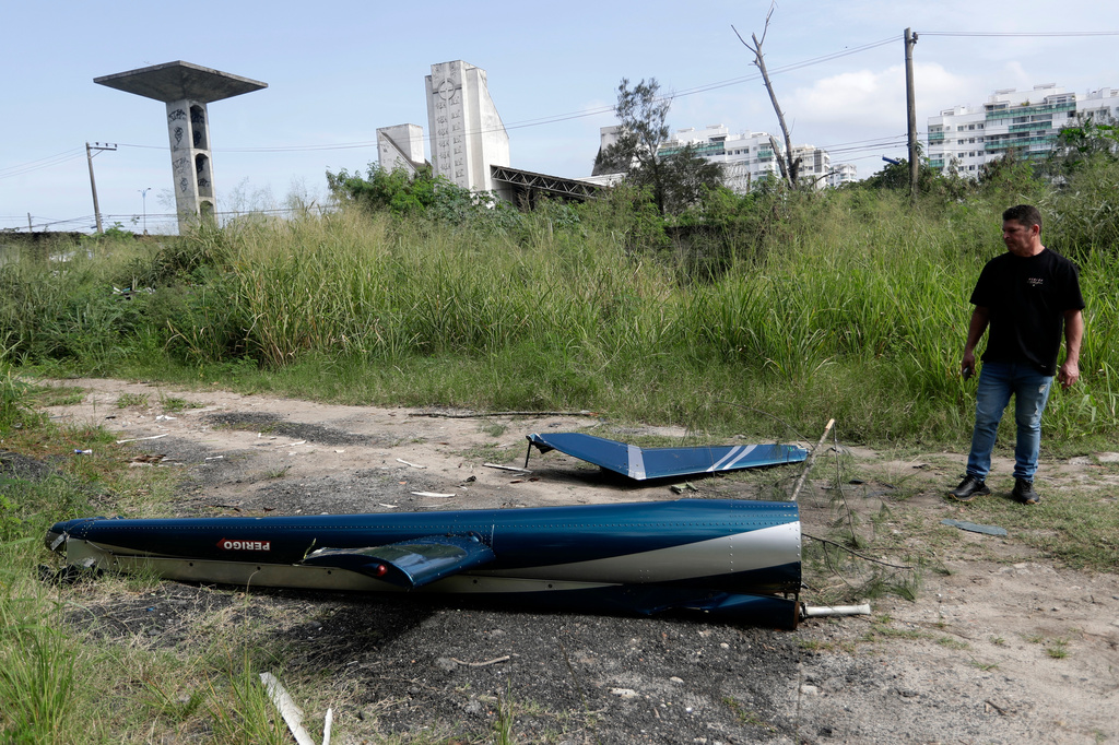 Aircraft debris lies near the site where two helicopters reportedly collided in midair and crashed into a car dealership parking lot in Rio de Janeiro, Brazil, Sunday, June 14, 2026. (AP Photo/Bruna Prado)