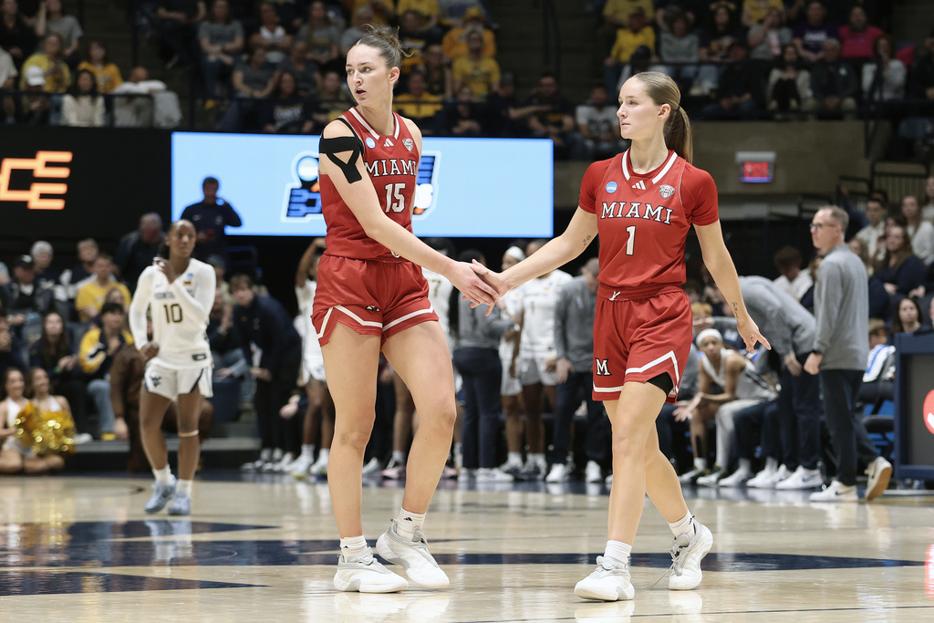 Miami (Ohio) forward Amber Tretter (15) and guard Amber Scalia (1) celebrate in the first half against West Virginia in the first round of the NCAA college basketball tournament, Saturday, March 21, 2026, in Morgantown, W.Va. (AP Photo/Kathleen Batten)