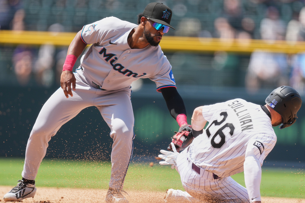 Miami Marlins shortstop Otto Lopez, left, tags out Colorado Rockies' Brett Sullivan as he tries to steal second base in the fourth inning of a baseball game Thursday, July 2, 2026, in Denver. (AP Photo/David Zalubowski)