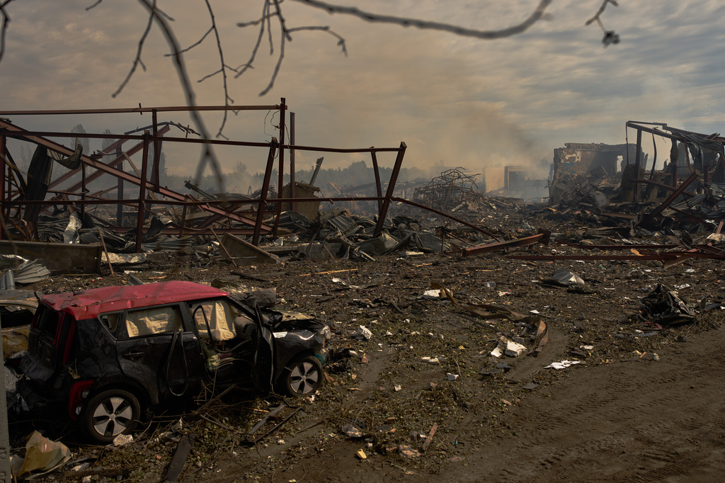 Destroyed vehicles and debris are scattered the day after a Russian attack struck a warehouse, followed by an explosion, in the village of Myla, outskirts of Kyiv, Sunday, Aug. 30, 2026. (AP Photo/Francisco Seco)