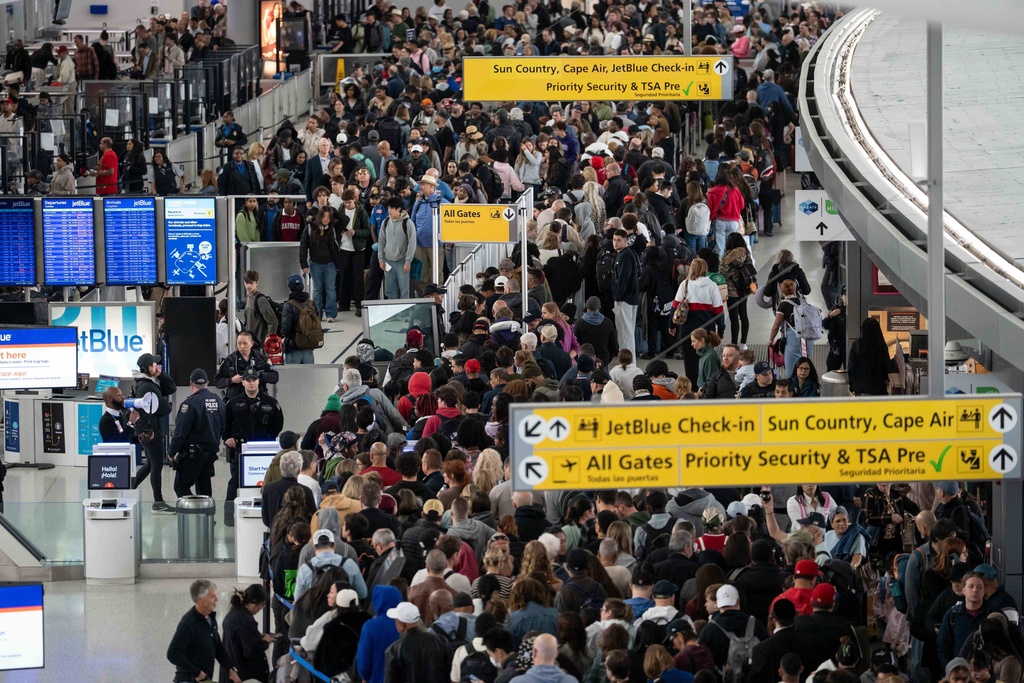 People wait in a TSA line at the John F. Kennedy International Airport, Sunday, March 22, 2026, in New York. (AP Photo/Yuki Iwamura)
