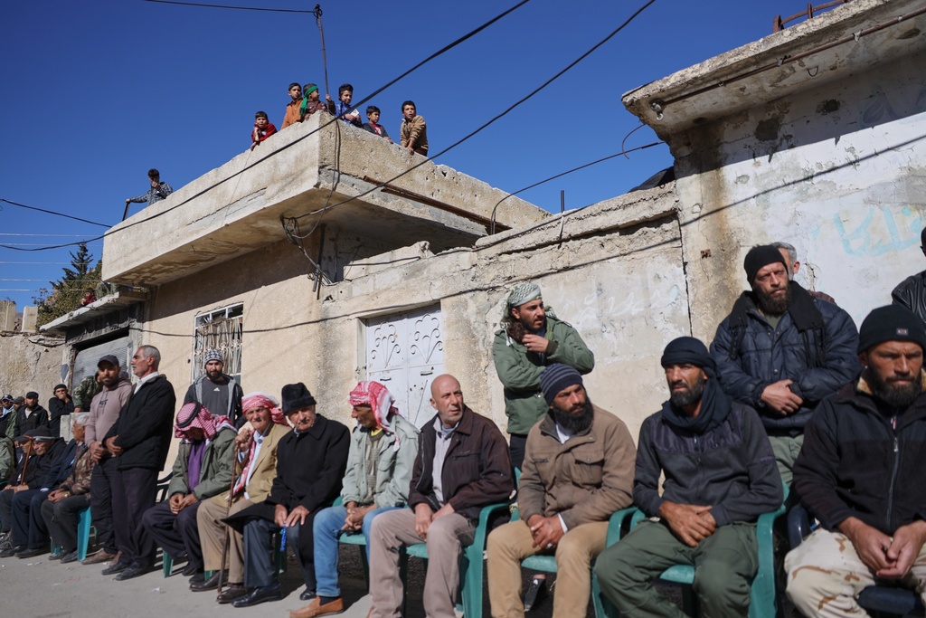 Local residents gather to welcome a delegation showing support after Israeli troops raided the village on Nov. 28, in Beit Jin, southwestern Syria, Monday, Dec. 1, 2025. (AP Photo/Omar Albam)
