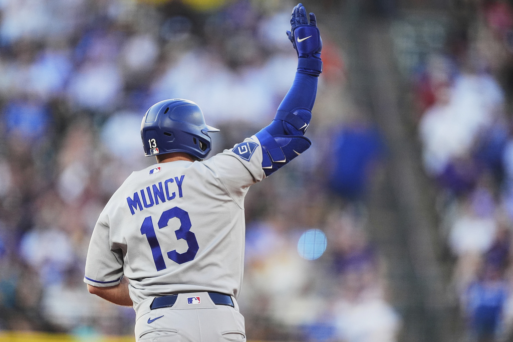 Los Angeles Dodgers' Max Muncy gestures to the bullpen as he circles the bases after hitting a three-run home run off Colorado Rockies starting pitcher Tomoyuki Sugano in the third inning of a baseball game Monday, Aug. 17, 2026, in Denver. (AP Photo/David Zalubowski)
