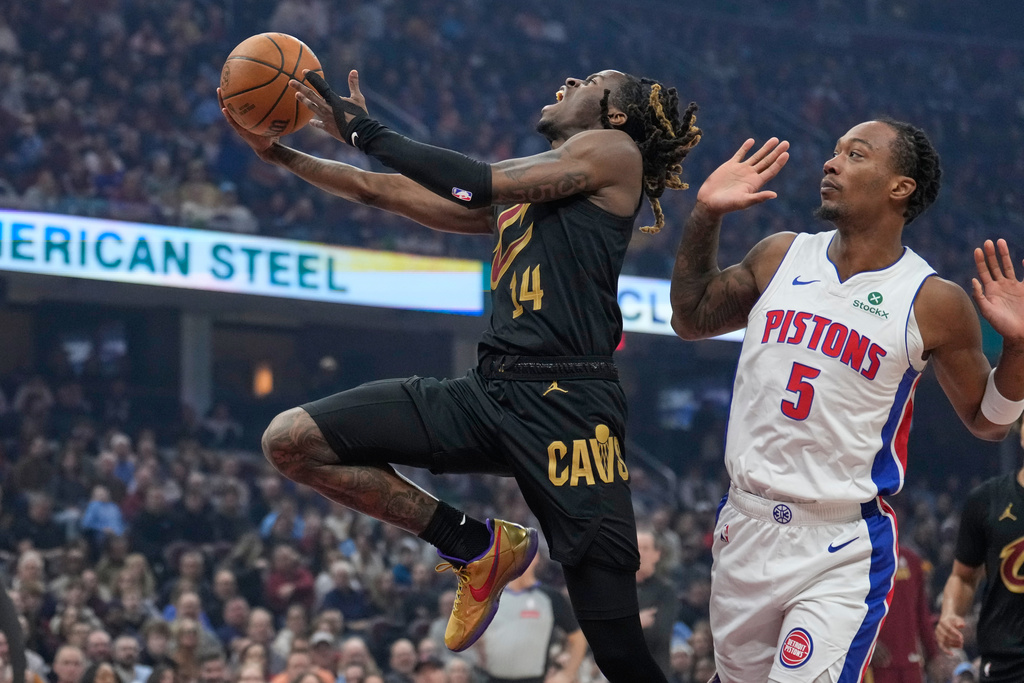 Cleveland Cavaliers guard Keon Ellis (14) goes to the basket past Detroit Pistons forward Ronald Holland II (5) in the first half of an NBA basketball game in Cleveland, Tuesday, March 3, 2026. (AP Photo/Sue Ogrocki)