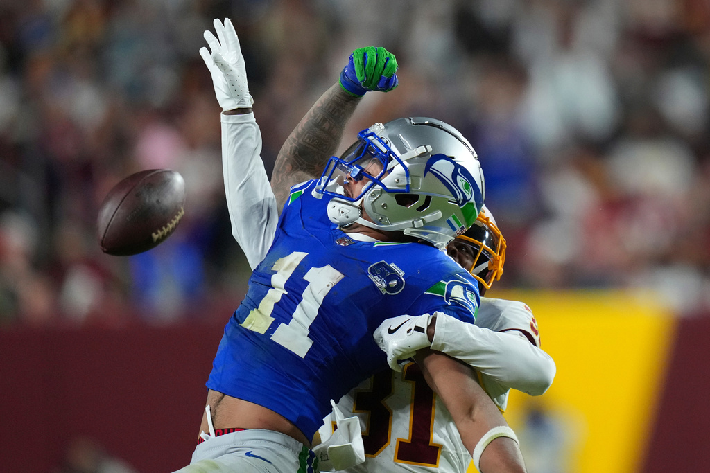 Washington Commanders cornerback Jonathan Jones (31) is called for pass interference against Seattle Seahawks wide receiver Jaxon Smith-Njigba (11) during the second half of an NFL football game, Sunday, Nov. 2, 2025, in Landover, Md. (AP Photo/Stephanie Scarbrough)