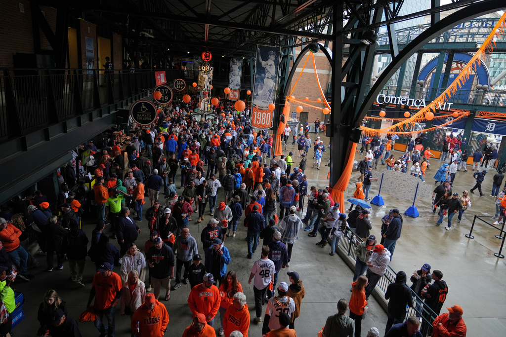 Fans seek shelter inside a concourse at Comerica Park as a light rain falls before Game 3 of baseball's American League Division Series between the Detroit Tigers and the Seattle Mariners Tuesday, Oct. 7, 2025, in Detroit. (AP Photo/Ryan Sun)