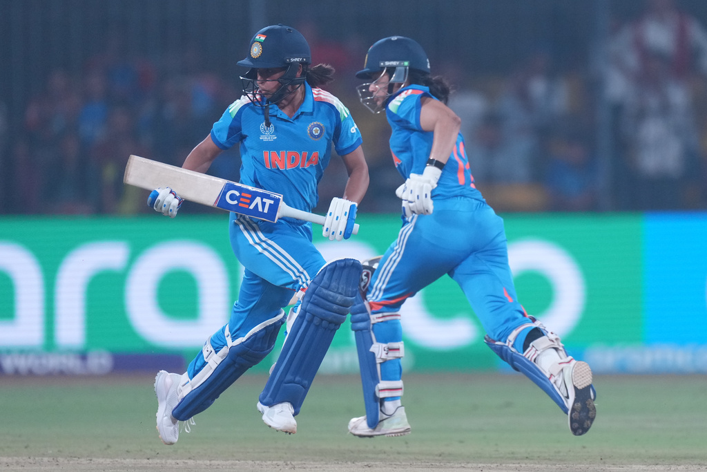 India's captain Harmanpreet Kaur, left, and Smriti Mandhana run between the wickets during the ICC Women's Cricket World Cup match between India and England in Indore, India, Sunday, Oct. 19, 2025. (AP Photo/Ajit Solanki)