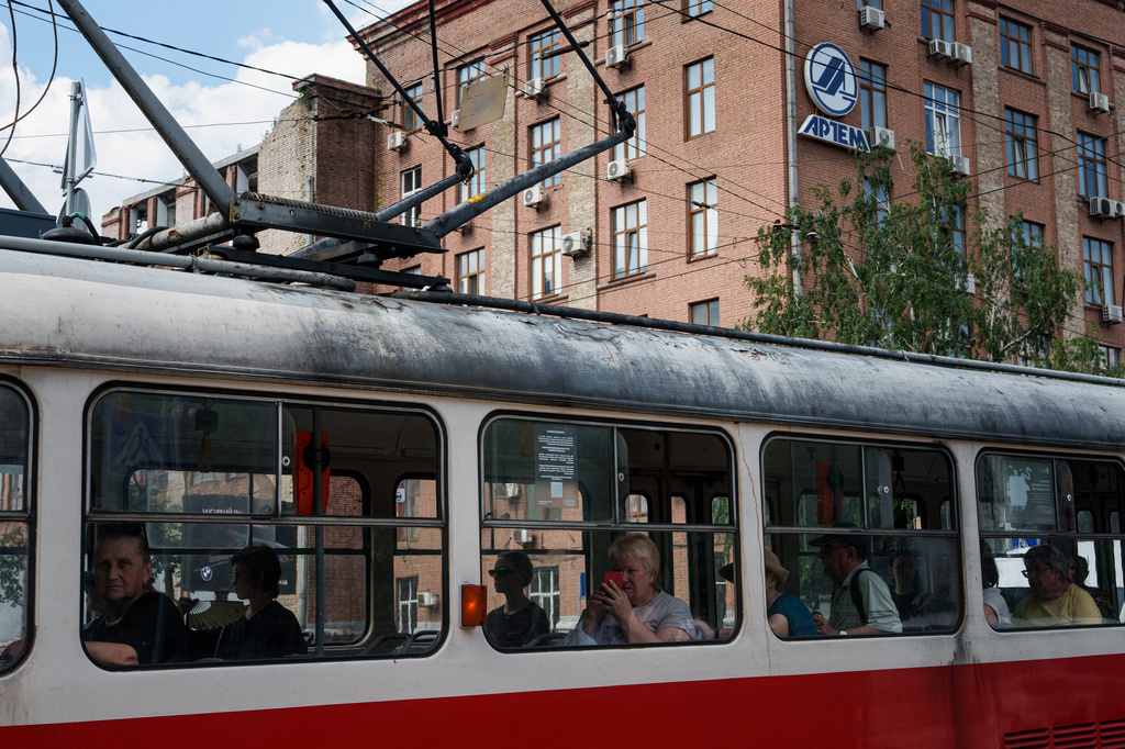 Commuters use the tram as they pass the Artem factory, a defense manufacturing facility, in the Lukianivka neighbourhood of Kyiv, Ukraine, Thursday, June 11, 2026. (AP Photo/Evgeniy Maloletka)