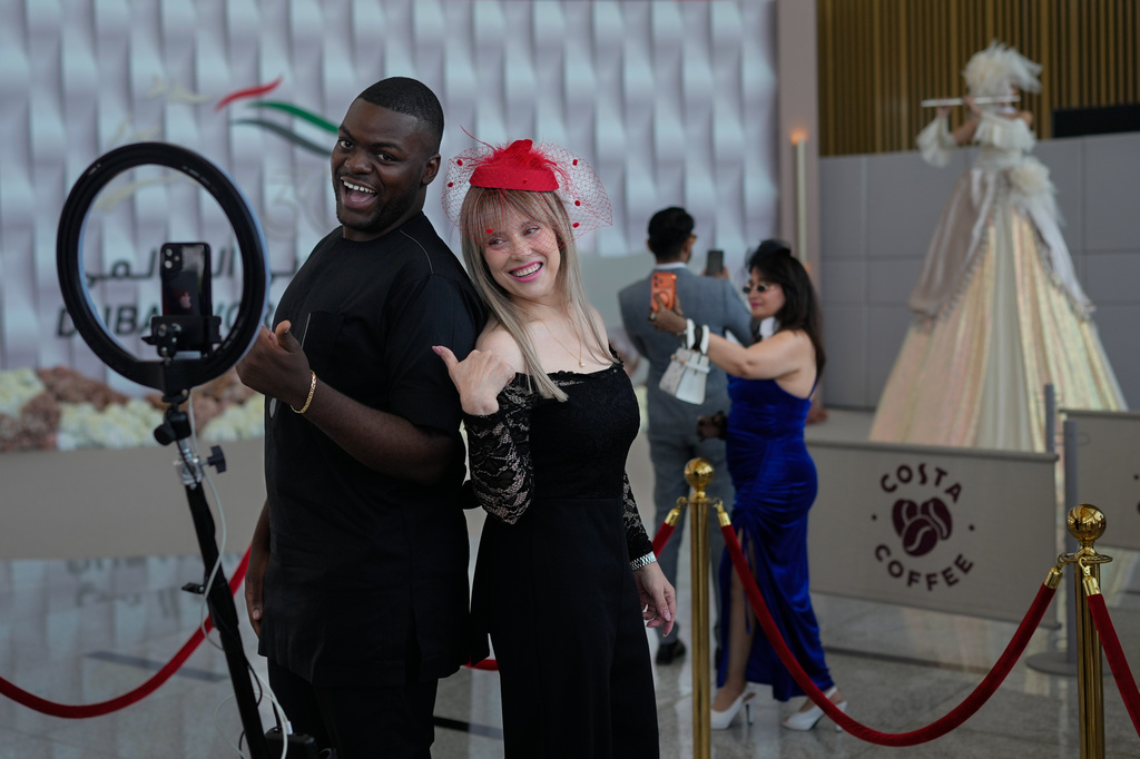 Racegoers pose for photos in the grandstand ahead of the Dubai World Cup at Meydan Racecourse in Dubai, United Arab Emirates, Saturday, March 28, 2026. (AP Photo/Altaf Qadri)