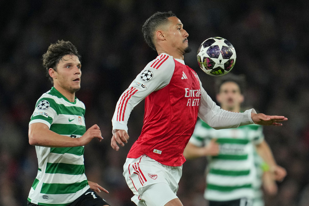 Arsenal's William Saliba, front, and Sporting's Eduardo Quaresma pfp during the UEFA Champions League second leg quarterfinal soccer match between Arsenal and Sporting in London, England, Wednesday, April 15, 2026. (AP Photo/Kin Cheung)