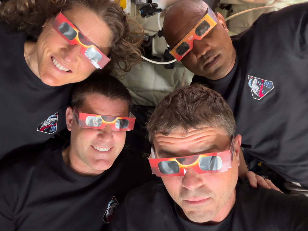FILE - In this image provided by NASA the Artemis II crew, counterclockwise from top left, Mission Specialist Christina Koch, Mission Specialist Jeremy Hansen, Commander Reid Wiseman and Pilot Victor Glover pose with eclipse viewers during a lunar flyby on April 6, 2026. (NASA via AP, File)