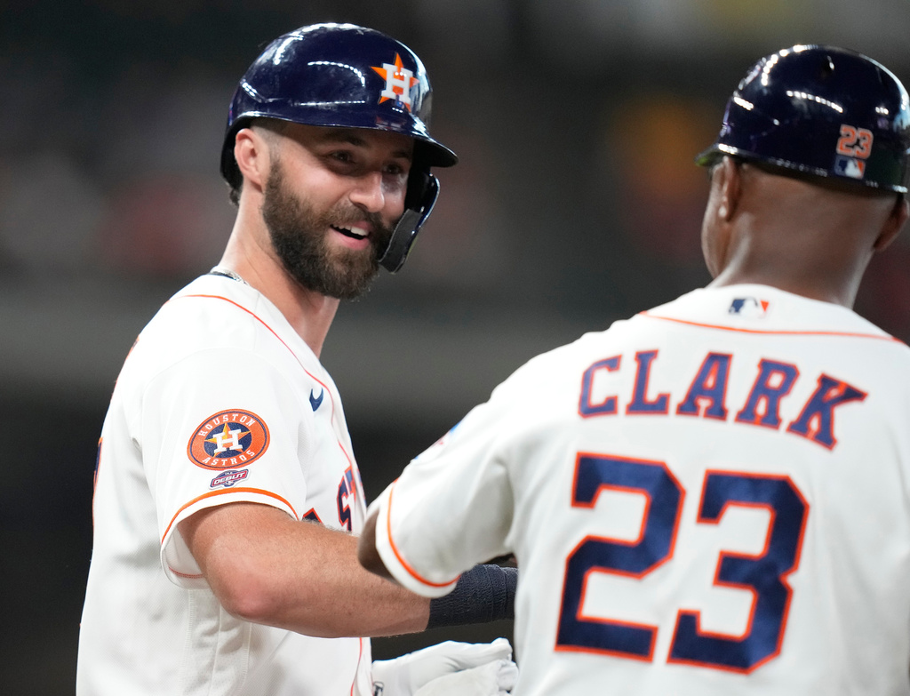 Houston Astros' Collin Price, left, greets first base coach Dave Clark (23) after being walked in his rookie debut by Pittsburgh Pirates starting pitcher Jared Jones during the second inning of a baseball game, Thursday, June 4, 2026, in Houston. (AP Photo/Karen Warren)
