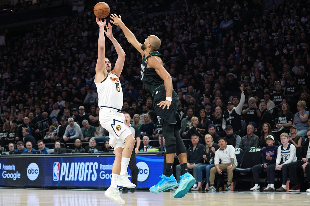 Denver Nuggets center Nikola Jokic (15) shoots over Minnesota Timberwolves center Rudy Gobert (27) during the first half of Game 4 of a first-round NBA basketball playoff series, Saturday, April 25, 2026, in Minneapolis. (AP Photo/Abbie Parr)