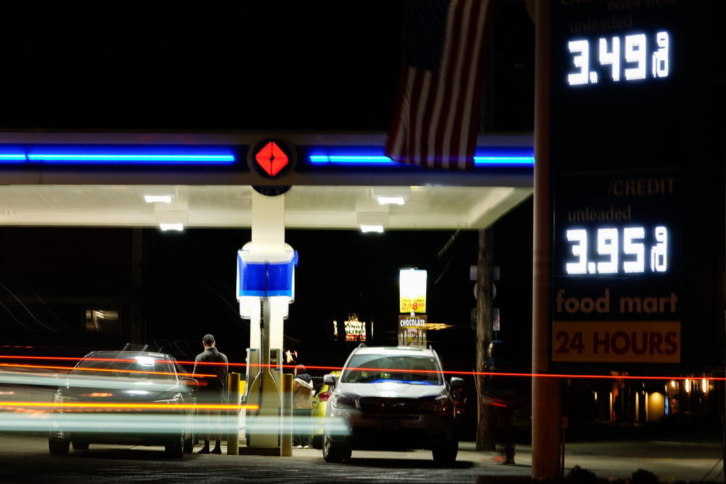 Vehicles drive past a gas station as a person puts gasoline in a vehicle on Sunday, March 8, 2026, in Portland, Ore. (AP Photo/Jenny Kane)
