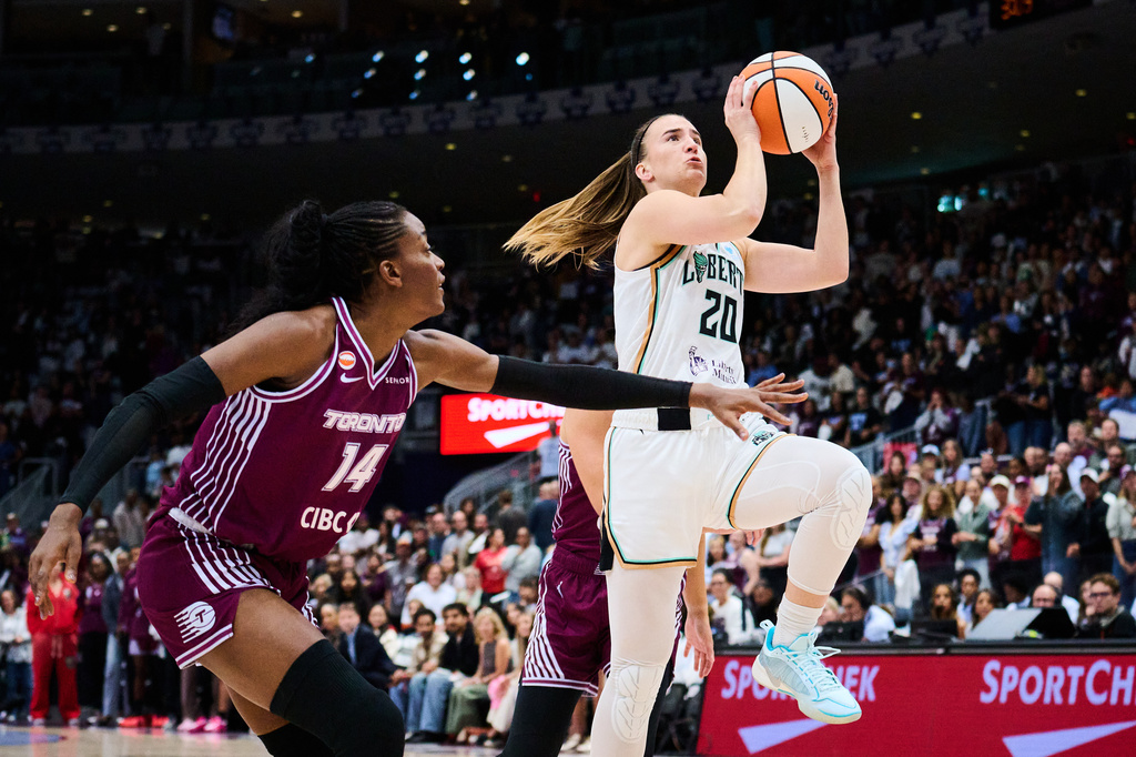 New York Liberty's Sabrina Ionescu (20) drives to the net past Toronto Tempo's Temi Fagbenle (14) during the first half of a WNBA basketball game in Toronto, Sunday, Sept. 20, 2026. (Sammy Kogan/The Canadian Press via AP)