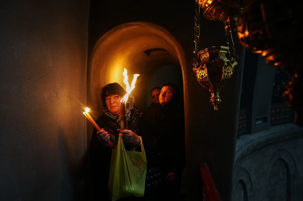FILE - Christian Orthodox pilgrims hold up candles during the Holy Fire ceremony, at the Church of the Holy Sepulcher in the Old City of Jerusalem, Saturday, April 11, 2026. (AP Photo/Mahmoud Illean, File)