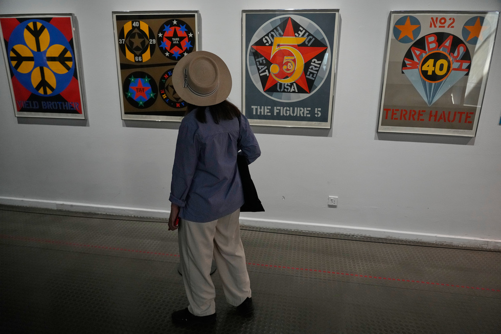 Iranian Artist Ghazaleh Jahanbin looks at screenprints of American artist Robert Indiana as she visits an exhibition called: "Art & war" displaying some artworks of American pop artists at the Tehran Museum of Contemporary Art in Iran, Thursday, May 7, 2026. (AP Photo/Vahid Salemi)