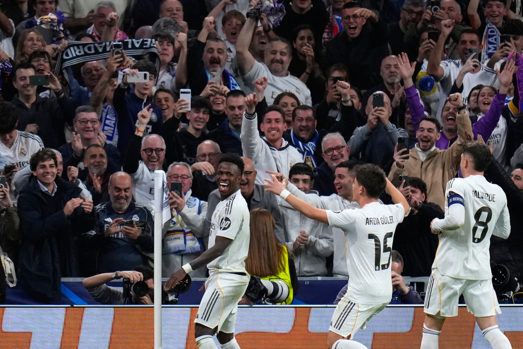 Real Madrid's Vinicius Junior, left, celebrates with teammates after scoring his side's second goal during the second leg of the Champions League playoff soccer match between Real Madrid and Benfica in Madrid, Spain, Wednesday, Feb. 25, 2026. (AP Photo/Manu Fernandez)