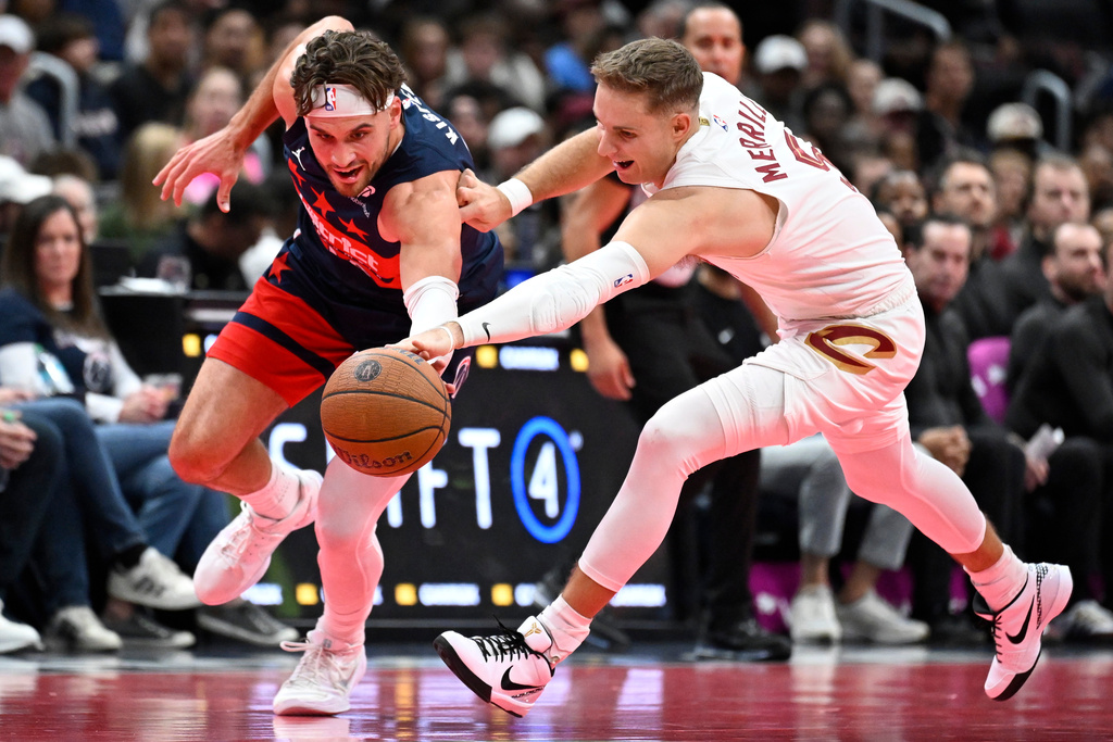 Washington Wizards forward Corey Kispert, left, competes for a loose ball against Cleveland Cavaliers guard Sam Merrill during the first half of an NBA Cup basketball game, Friday, Nov. 7, 2025, in Washington. (AP Photo/John McDonnell)