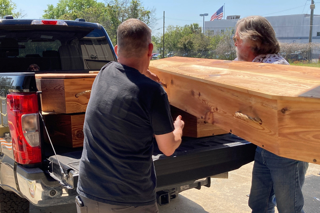 FILE - Forensic anthropologist Bill Stevens, left, and archeologist James Legg, right, handle homemade coffins in preparation of the reburial of the remains of unidentified Revolutionary War soldiers killed in the Battle of Camden in 1780 on Thursday, March 30, 2023, in Columbia, S.C. (AP Photo/Jeffrey Collins, File)