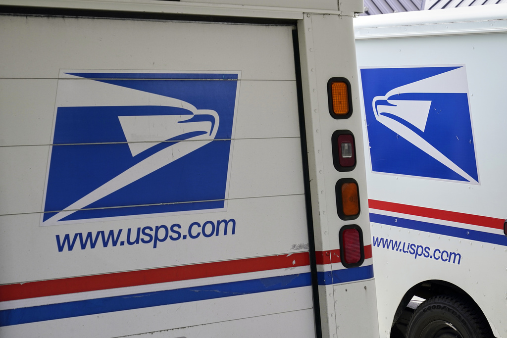 FILE - U.S. Postal Service delivery vehicles are parked outside a post office in Boys Town, Neb., Aug. 18, 2020. (AP Photo/Nati Harnik, File)