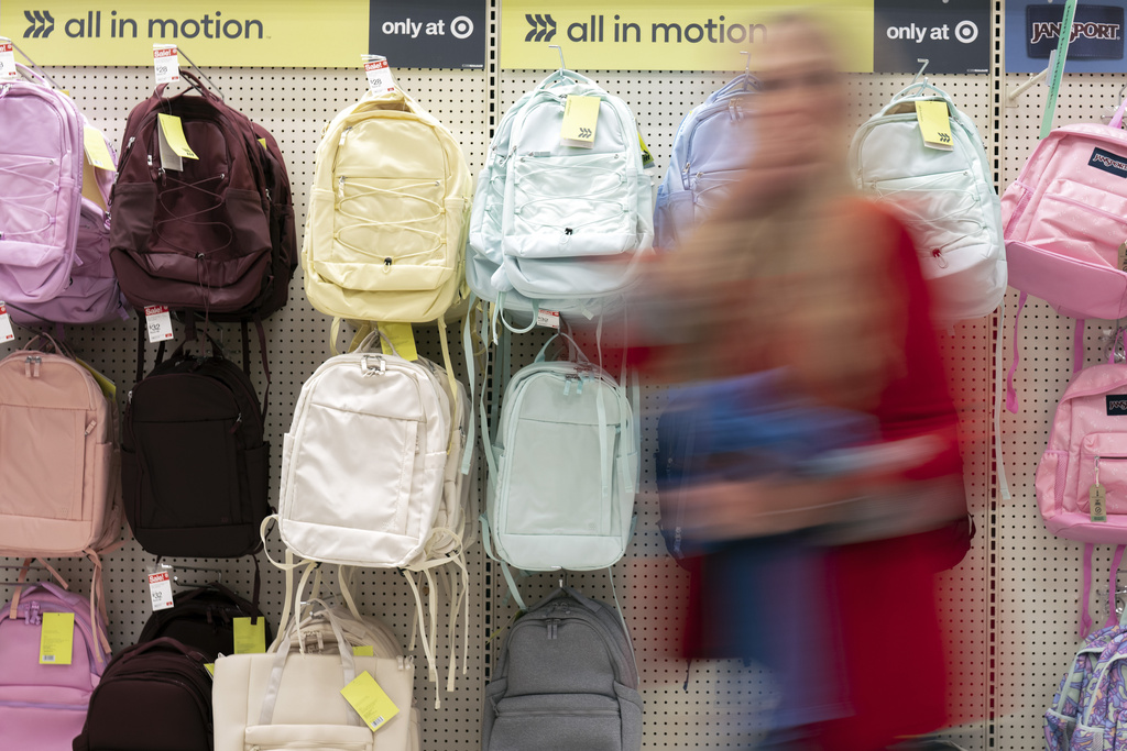 A person walks by backpacks displayed for sale in the back-to-school supplies section of a Target in Sherwood, Ore., Friday, Aug. 8, 2025. (AP Photo/Jenny Kane)