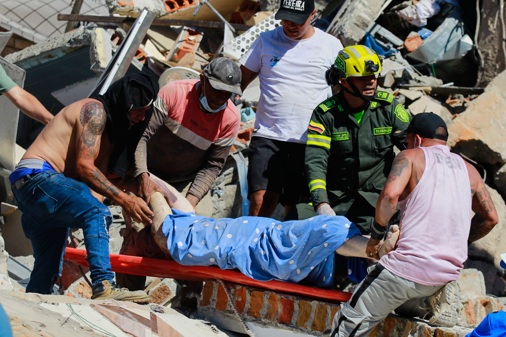 Residents and police carry a survivor pulled from the rubble after an earthquake struck Pereira, Colombia, Monday, Aug. 10, 2026. (AP Photo/Miguel Angel Lopez)