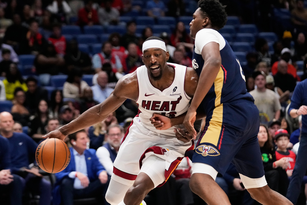 Miami Heat center Bam Adebayo (13) drives to the basket against New Orleans Pelicans center Derik Queen in the second half of an NBA basketball game, Wednesday, Feb. 11, 2026, in New Orleans. (AP Photo/Gerald Herbert)