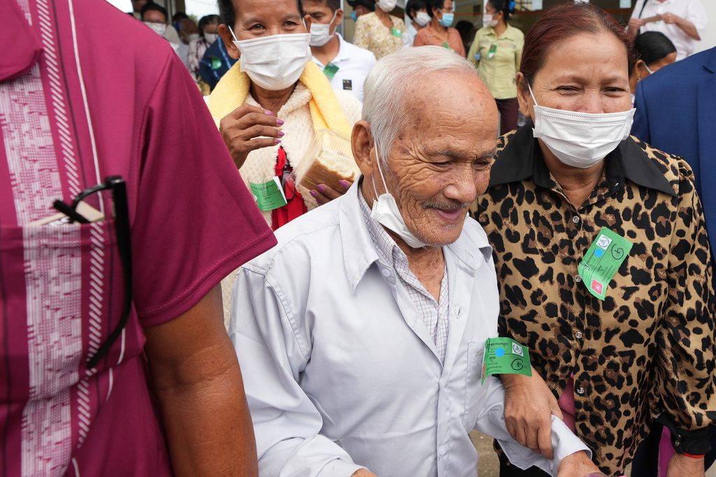 FILE- Bou Meng, center, former S-21 prison survivor, leaves the courtroom after the verdict is announced for Khieu Samphan, former Khmer Rouge head of state, at the U.N.-backed war crimes tribunal in Phnom Penh, Cambodia, Thursday, Sept. 22, 2022. (AP Photo/Heng Sinith, file)