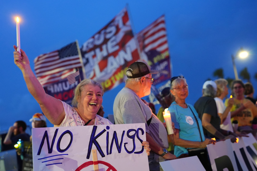 FILE - Dee Cahill of Margate, Fla., holds a "No Kings" sign as she participates in a pro-democracy, anti-Trump protest outside Trump's Mar-a-Lago estate in Palm Beach, Fla., Thursday, July 17, 2025. (AP Photo/Rebecca Blackwell, File)